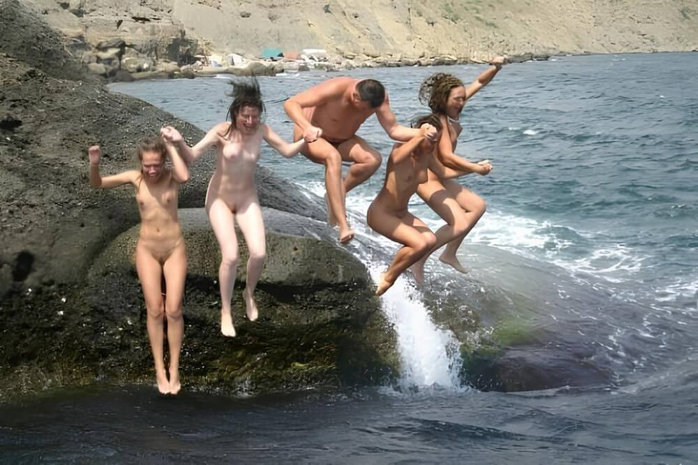 Mens and girls nudists on a beach - In nude recreation, harmony with nature and inner balance are important