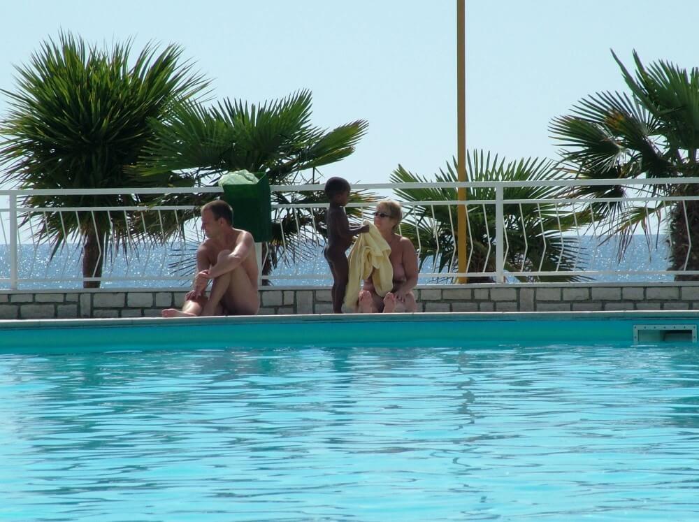 Photo of naturists in an outdoor pool - Living in harmony with nature is a defining characteristic of the naturist and nudist community
